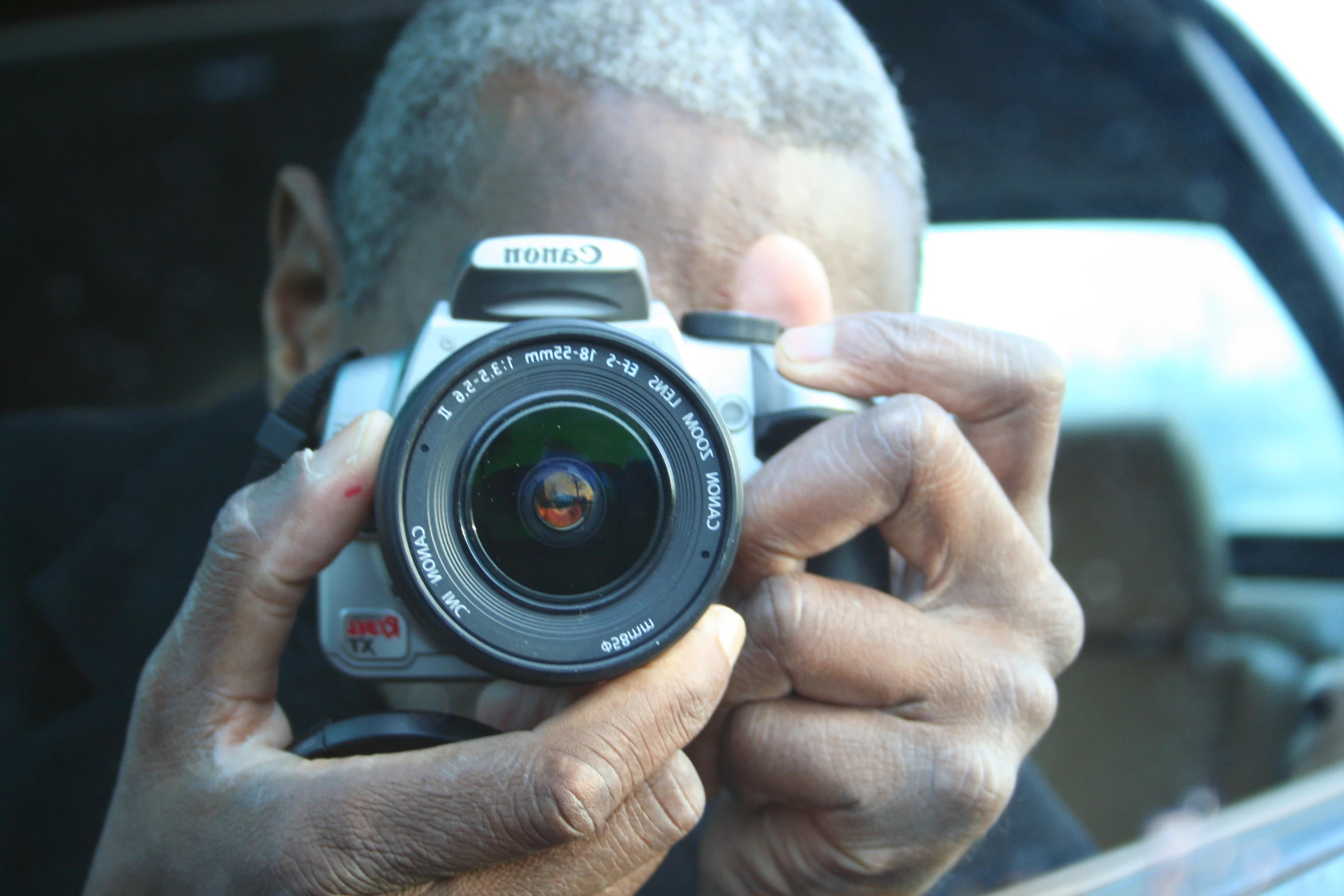 a man holding a camera up to take a po