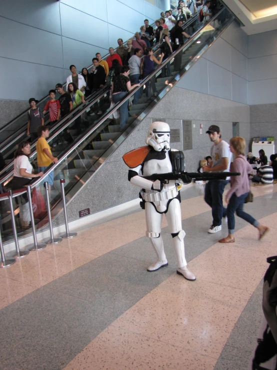 a man in the form of a stormtrooper carries a tray with pizza on it