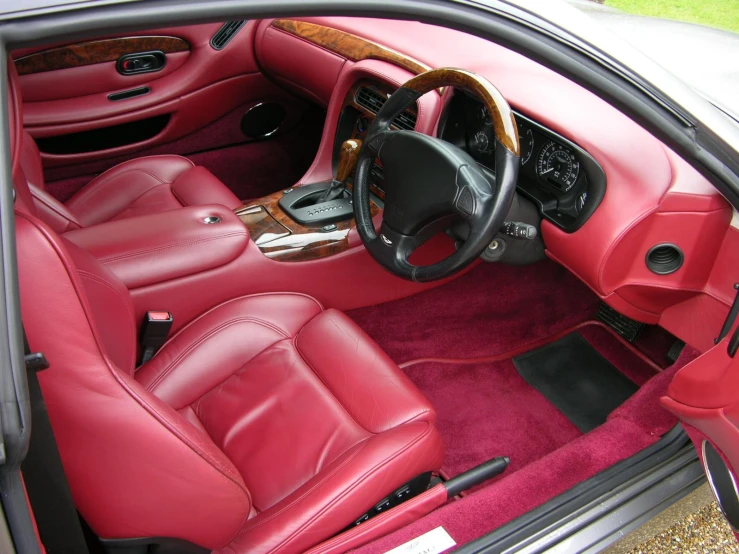 the interior of a car with a red carpet and red seat covers