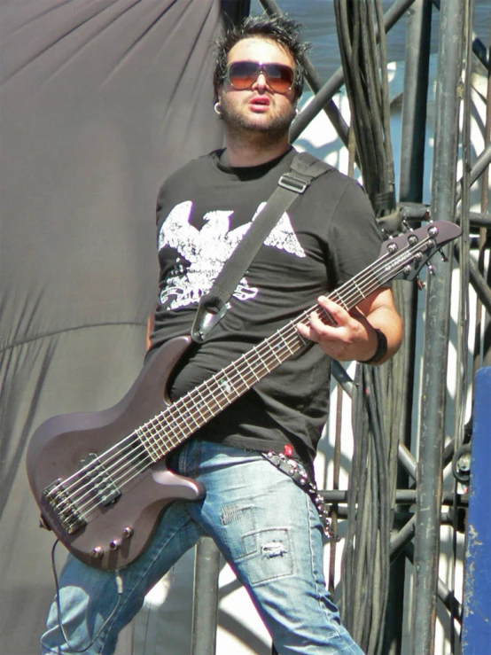 a man with a bass is playing in front of a microphone