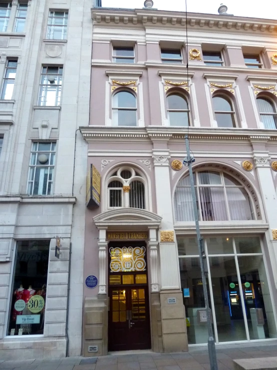 a tall white and tan building with clocks on it