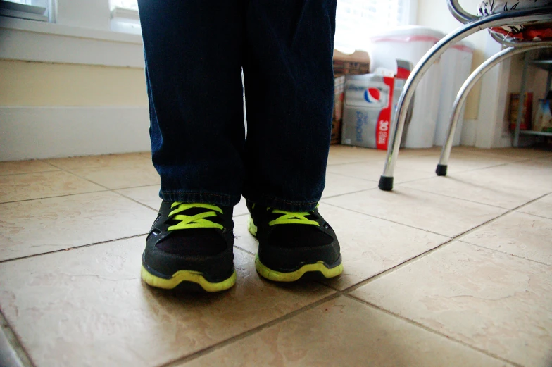 a person wearing black and yellow shoes standing on the ground