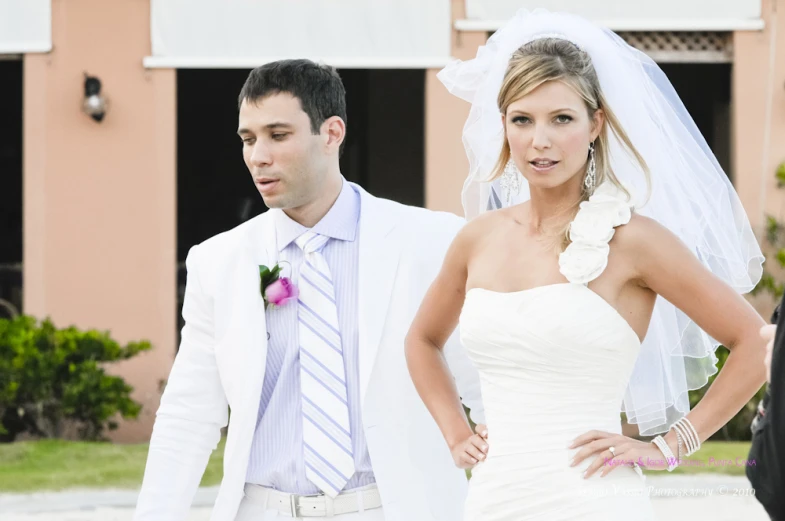 a man standing next to a woman in a wedding dress