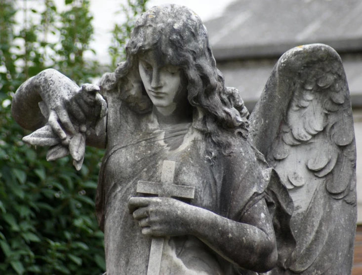 a statue of an angel holding a book