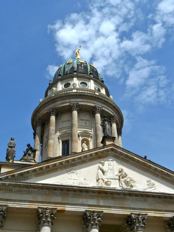a tall building with a dome and statues on top