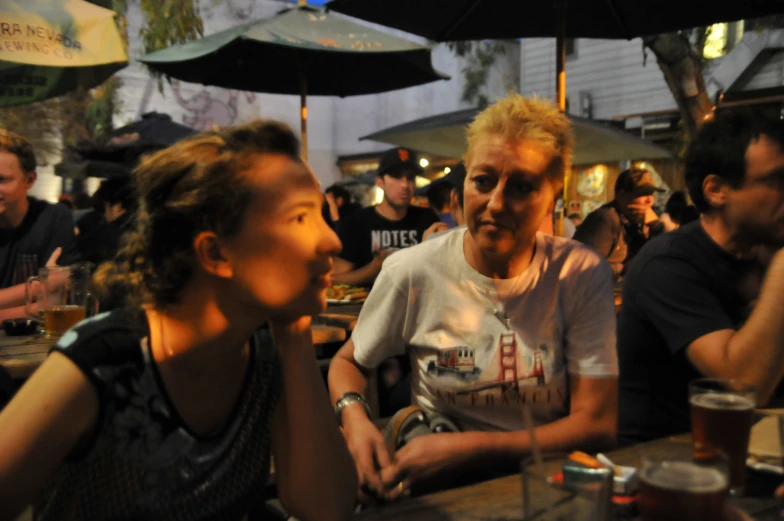 a man sitting in front of two women talking