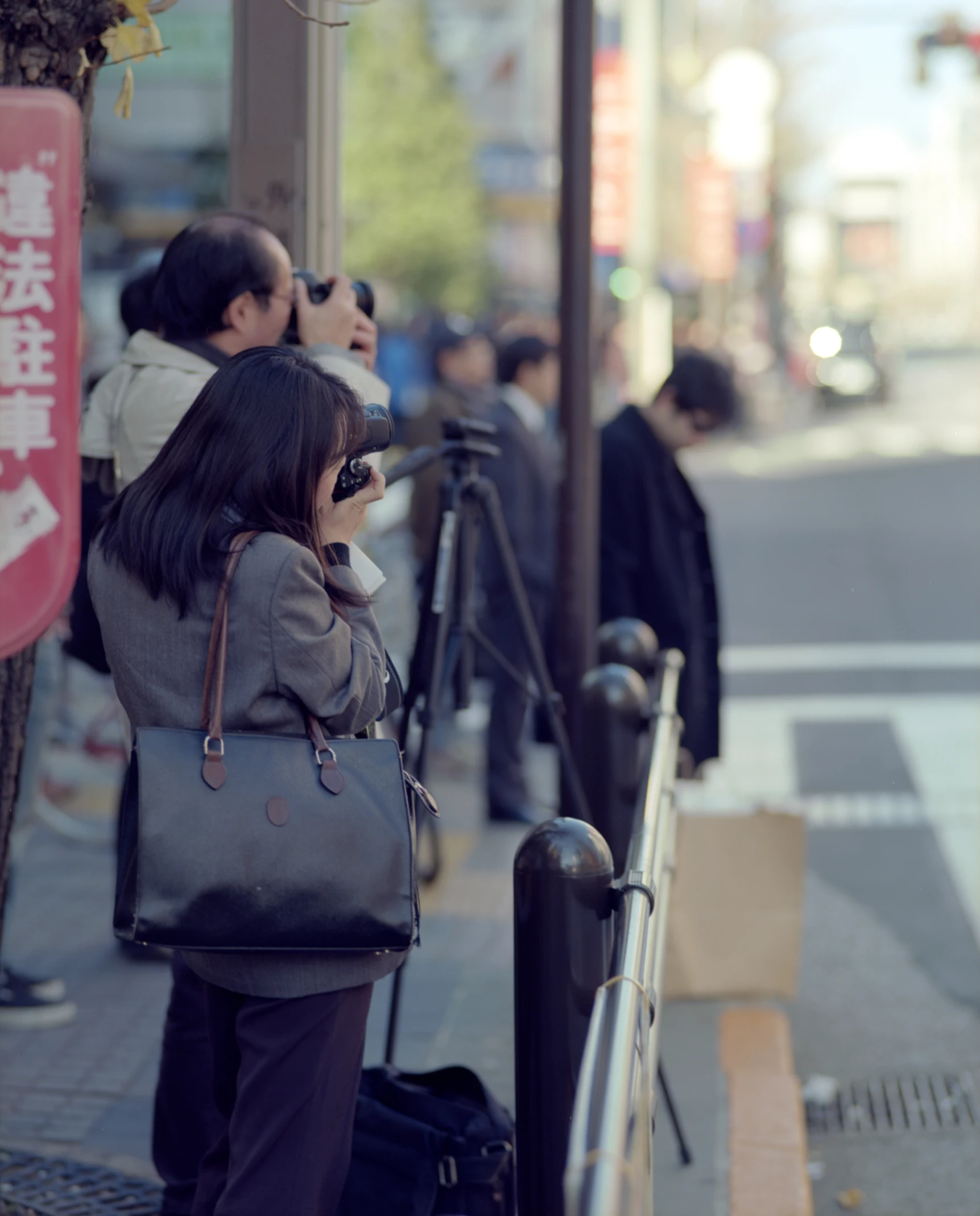 some people and luggage on the sidewalk and some buildings