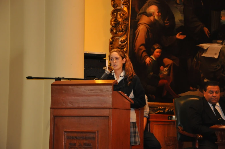 a woman standing at a podium during a speech