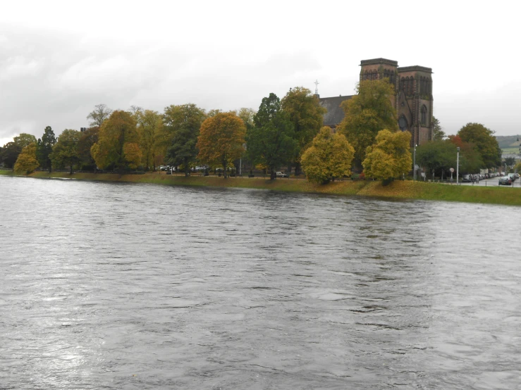 a lake near a castle in autumn with yellow and green foliage