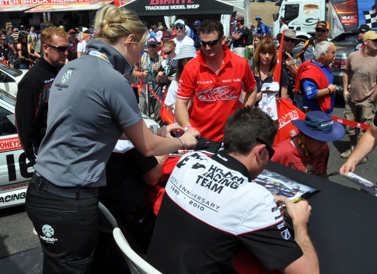 a group of people gathered around a small race car