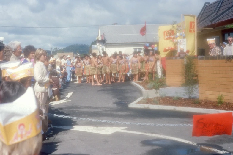 a parade with several people in white and orange attire