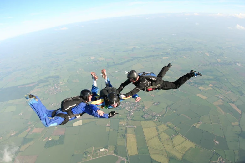 two people jumping into the air and two persons wearing parachute suits