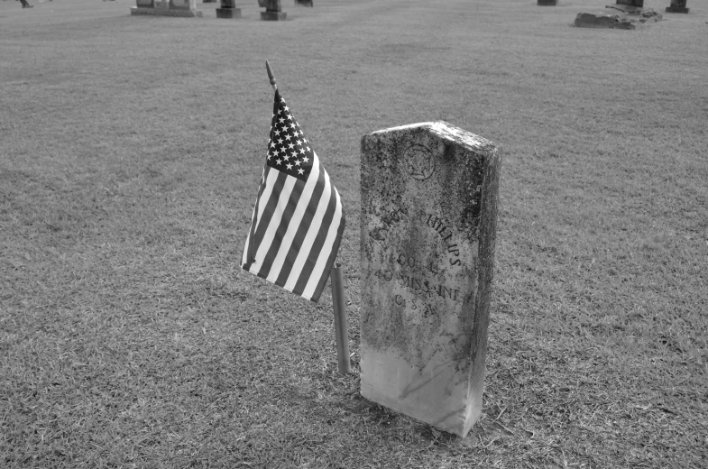 the american flag is sitting on top of an old grave