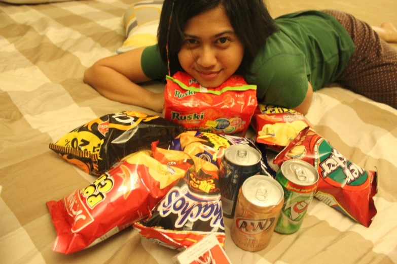 a person laying on a bed with several items stacked up