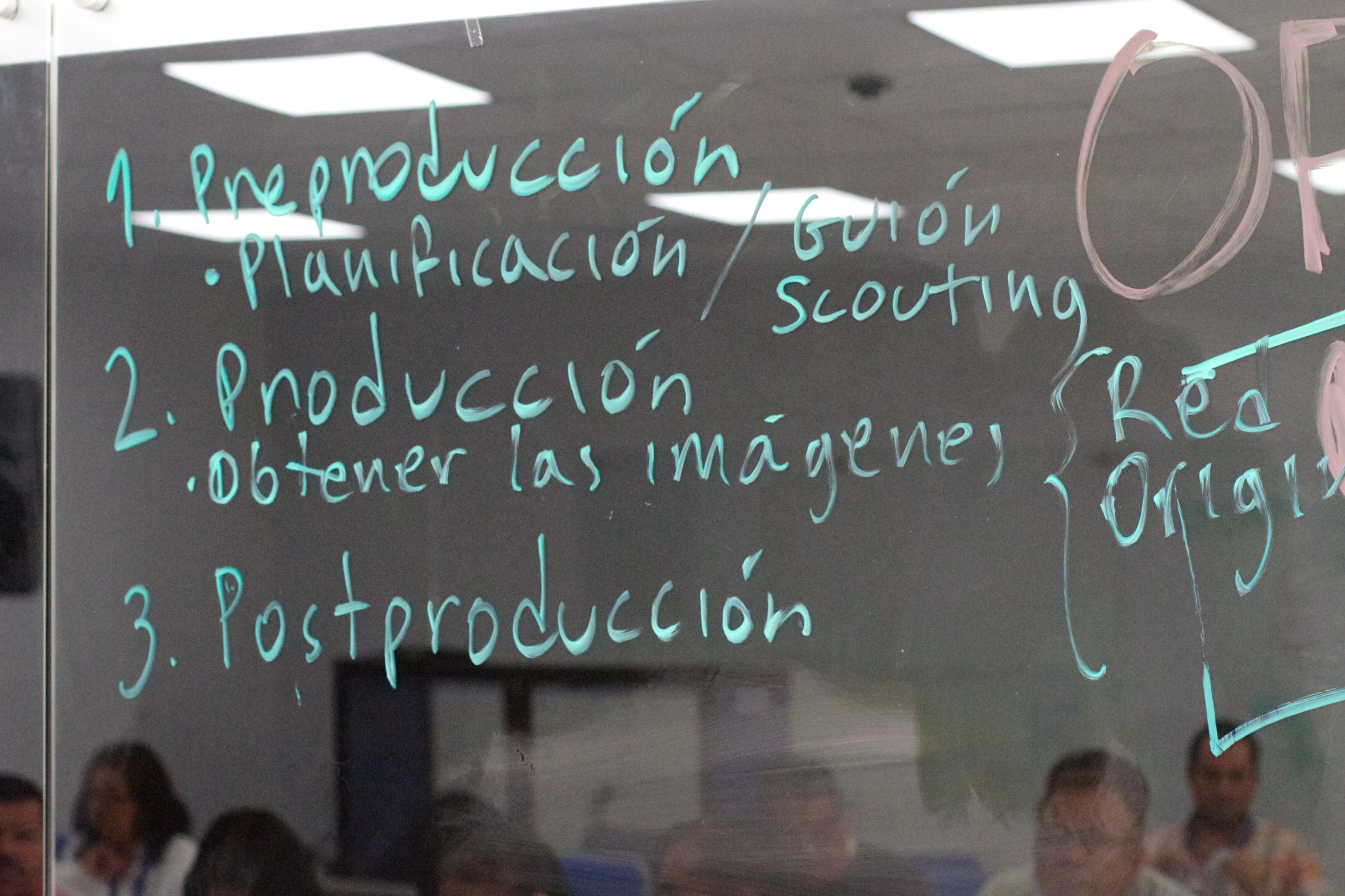 many people are in the background with a large black board that has writing on it