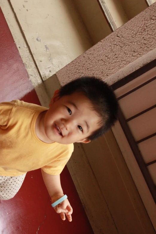 a small child with a yellow shirt and some paper on it