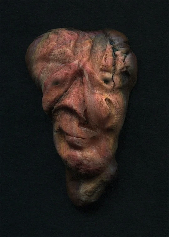 a pograph of a face made out of clay
