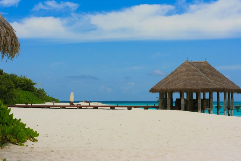 there is a thatched hut on the beach