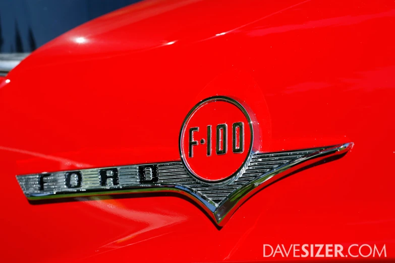 a close up of the emblem on an old red car