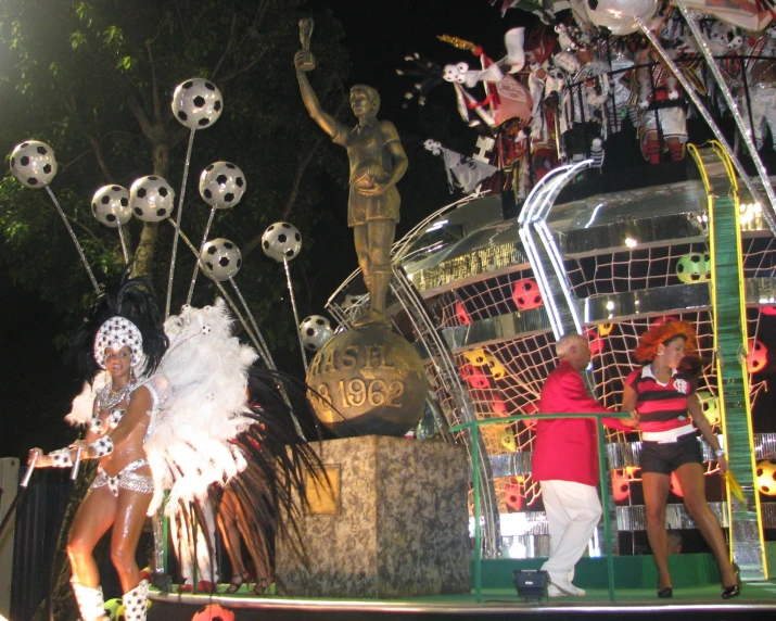 a performer and people watch from stage near soccer balls