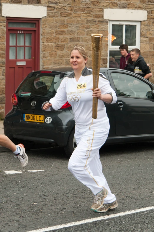 a woman is carrying a large stick on a road