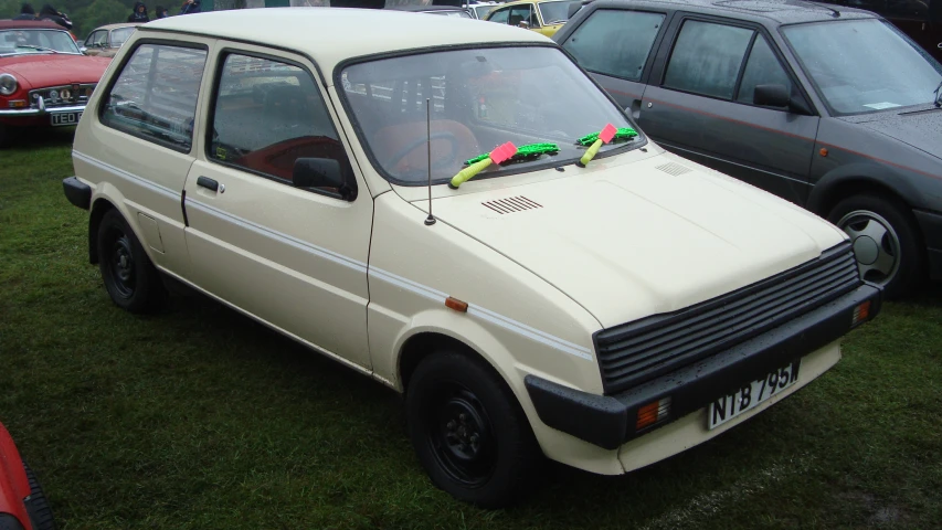 several cars parked on top of a grass covered field