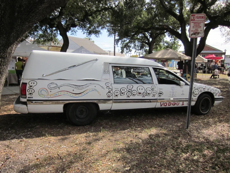 a van parked in front of a tree on top of a field