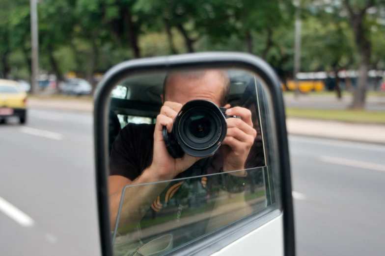 a person holding a camera in front of a mirror
