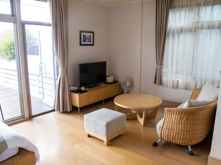 a living room with a wooden floor, white couch, and tv