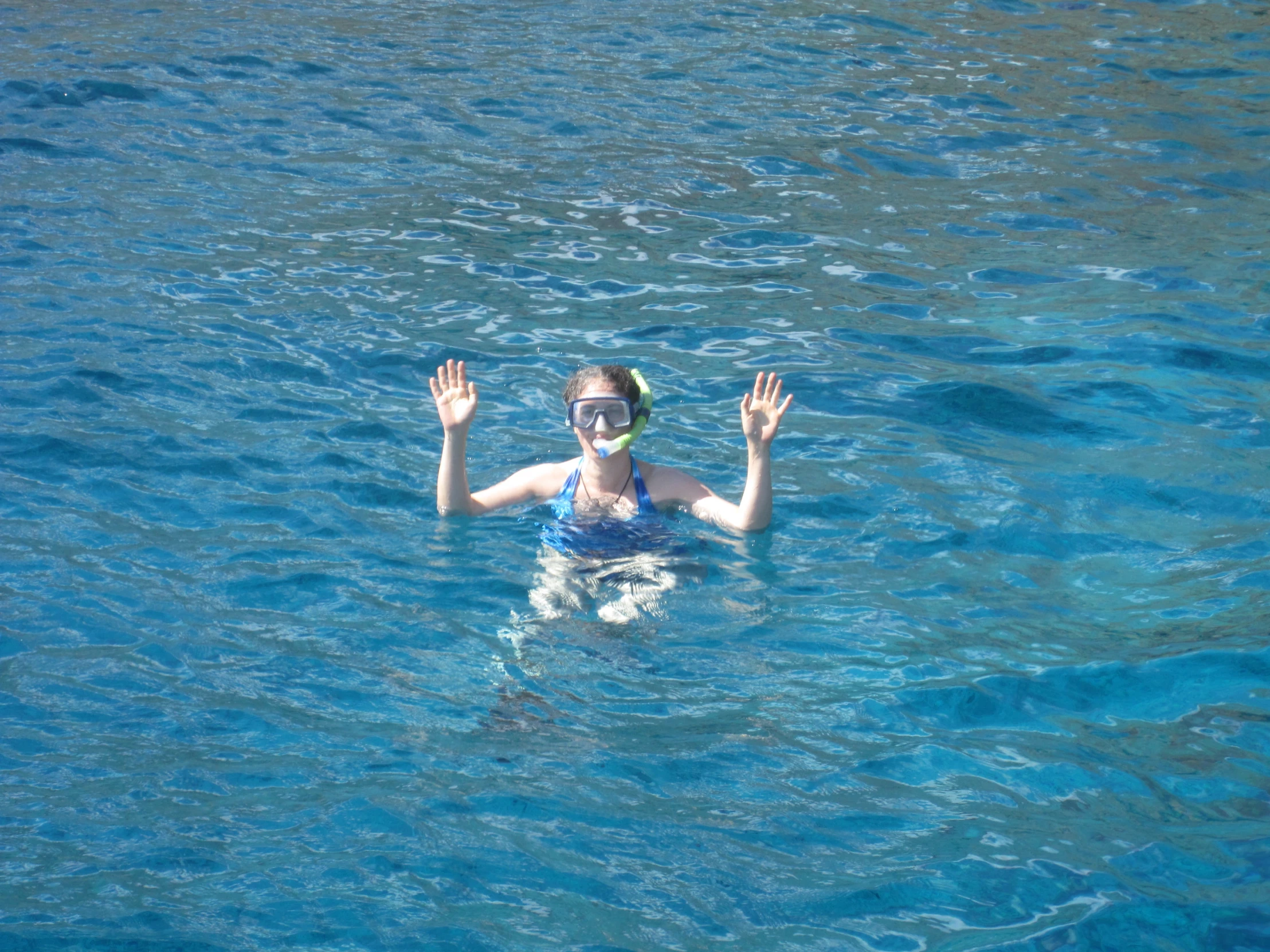 a woman standing in the water holding her hands up