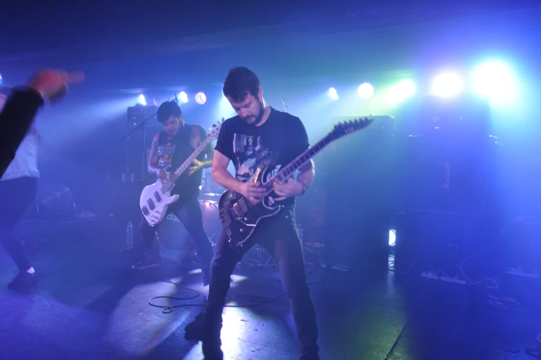 three men on stage playing a musical instrument