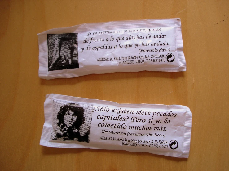 two rolled up paper packets with some writing on them