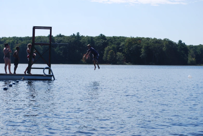 people standing on a platform above the water