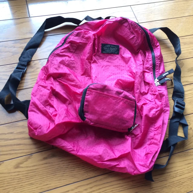 a pink back pack sitting on the floor