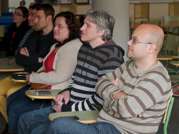 a group of people sitting on some tables in a row