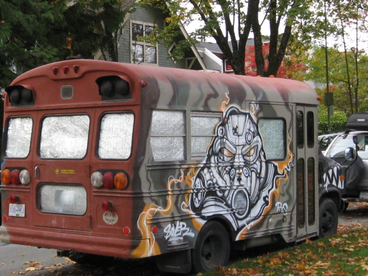 a colorful bus covered in graffiti sitting on the side of the road