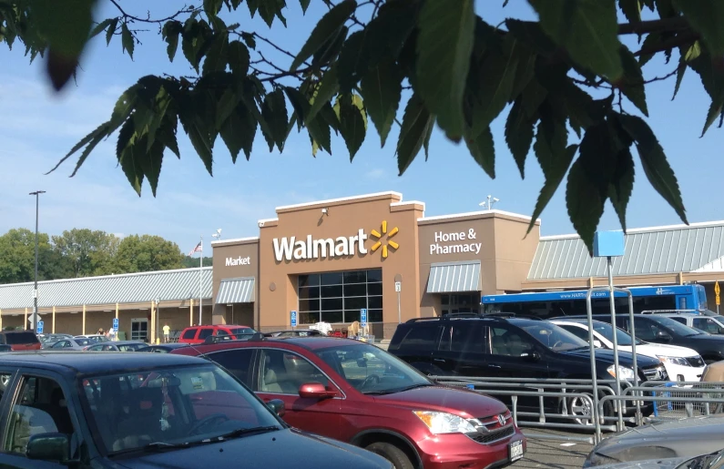 cars parked in front of a walmart on the street