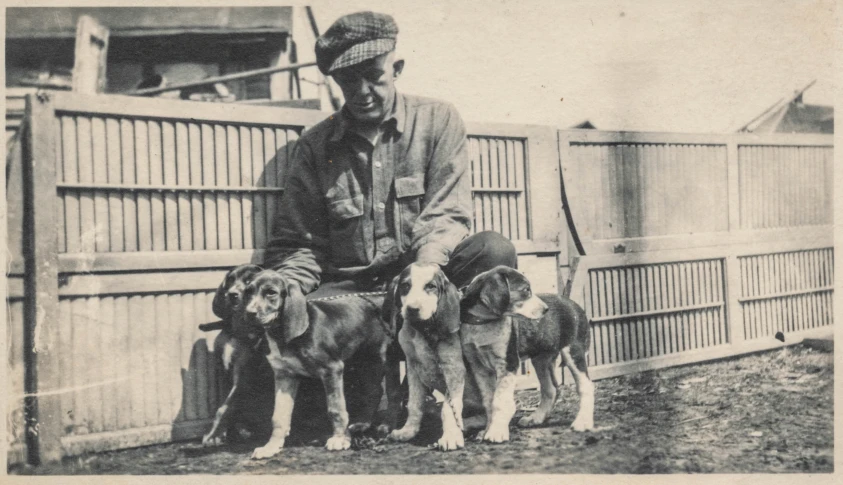 black and white pograph of a man holding dogs