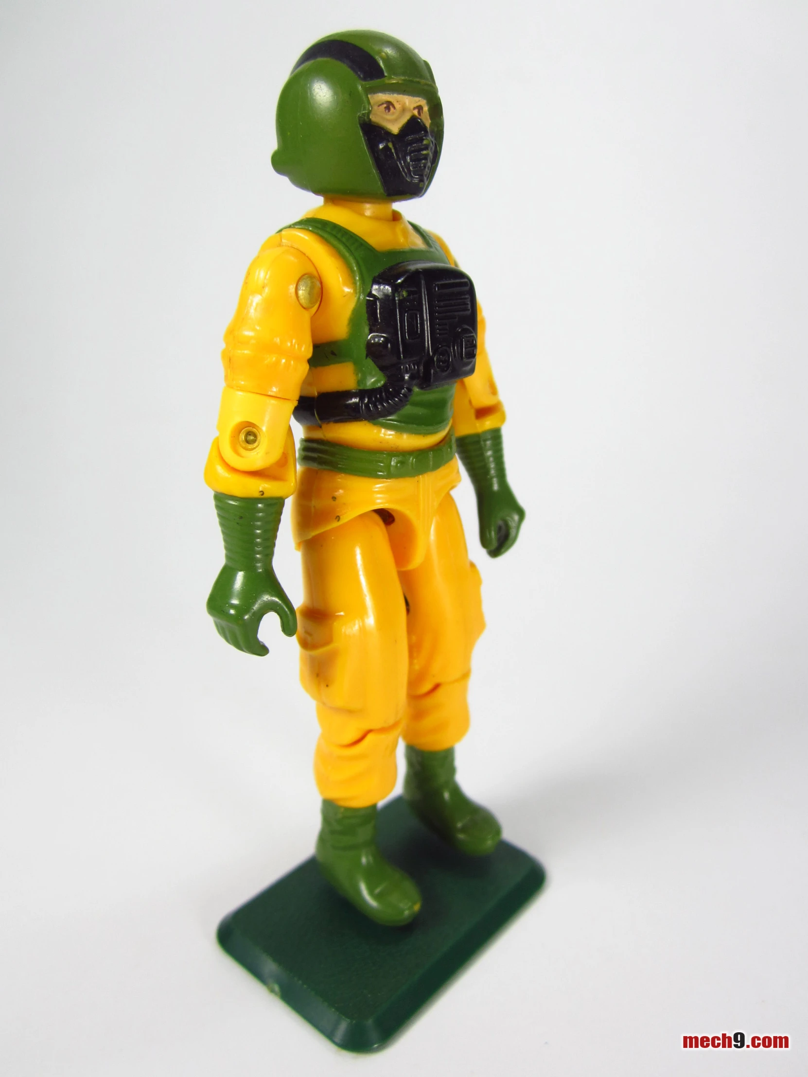 the action figure is yellow and green with a black mask
