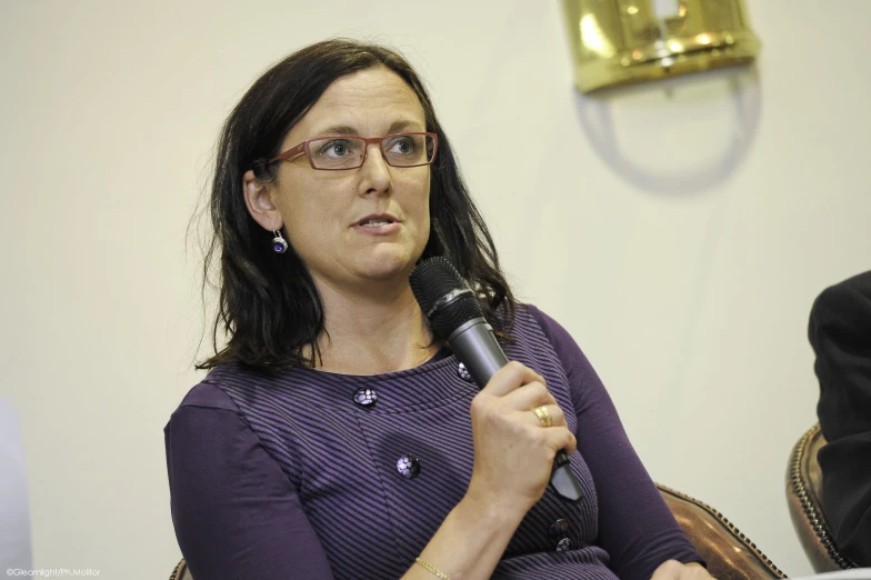 a woman speaking into a microphone in a room