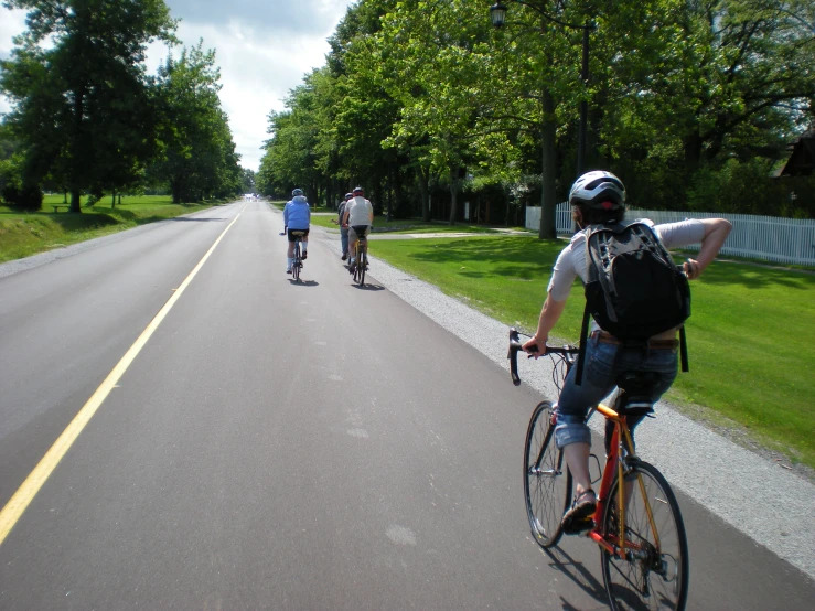 three people riding bikes down a street together