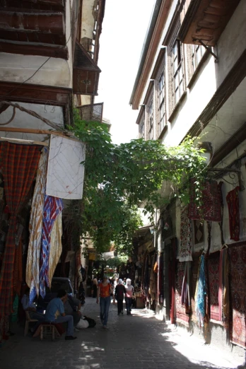 narrow alleyway with people shopping in outdoor shops