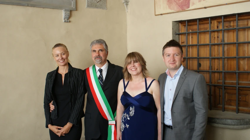 four people standing and posing for the camera