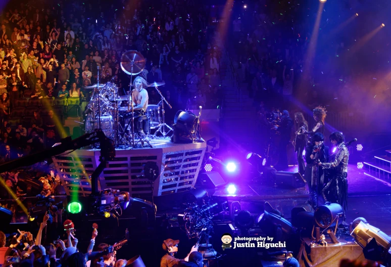 a crowd is shown at night, watching a band perform