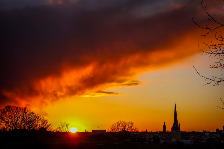 a sunset seen over a large city with silhouetted buildings