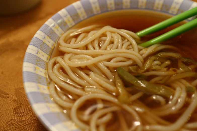 a bowl of asian noodle soup is shown with chopsticks