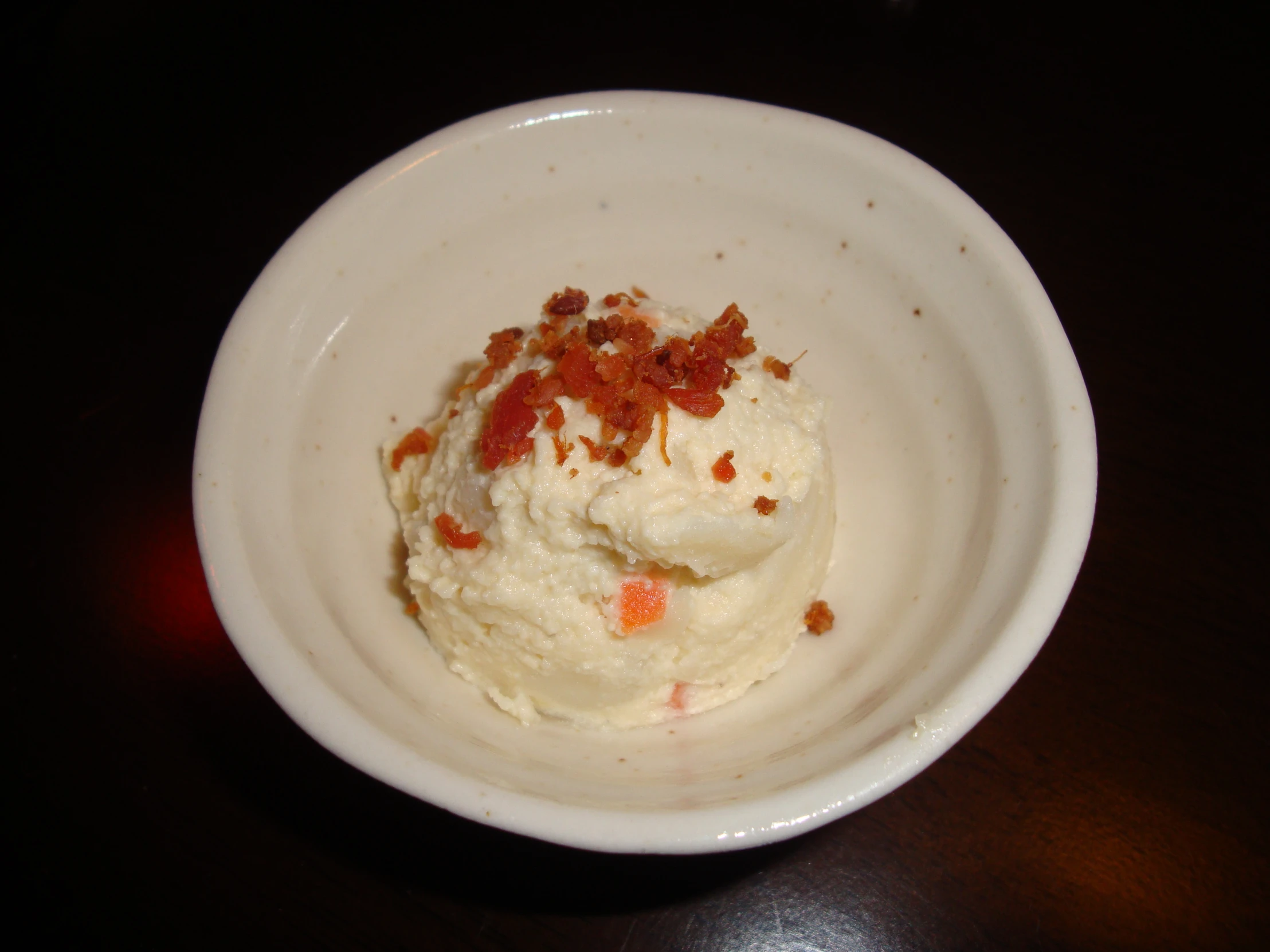 a white bowl of food on top of a wooden table