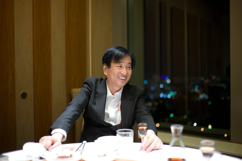 the man is smiling while sitting at a table