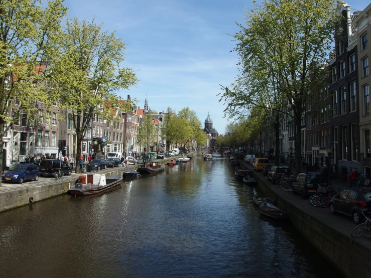 a canal next to buildings and other parked cars