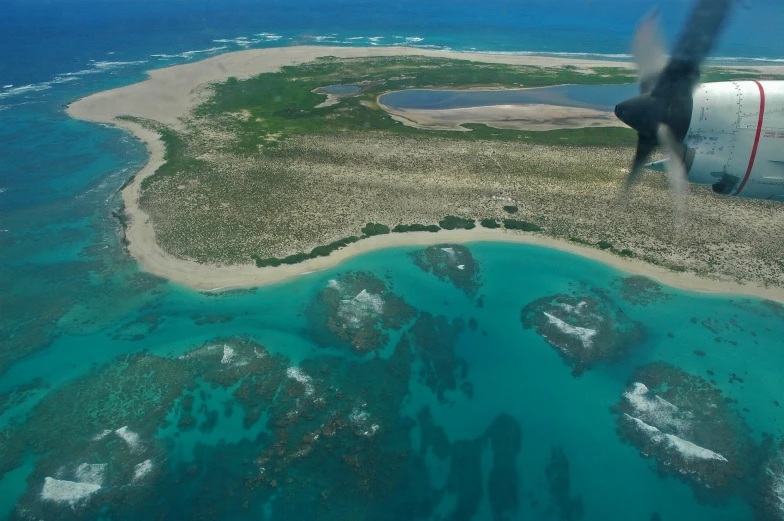 the airplane flying over an island in the water